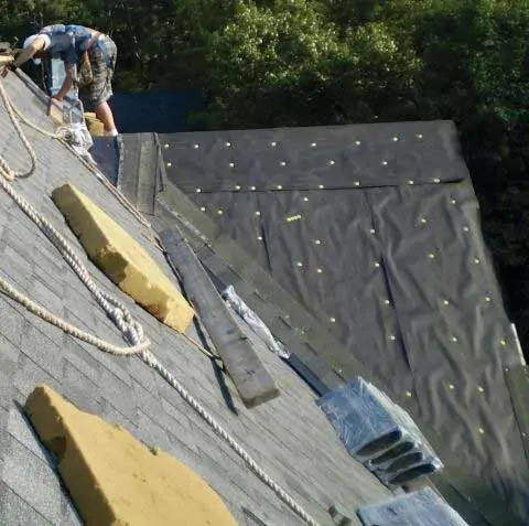 Roofing professionals adding underlayment as part of roof repair.