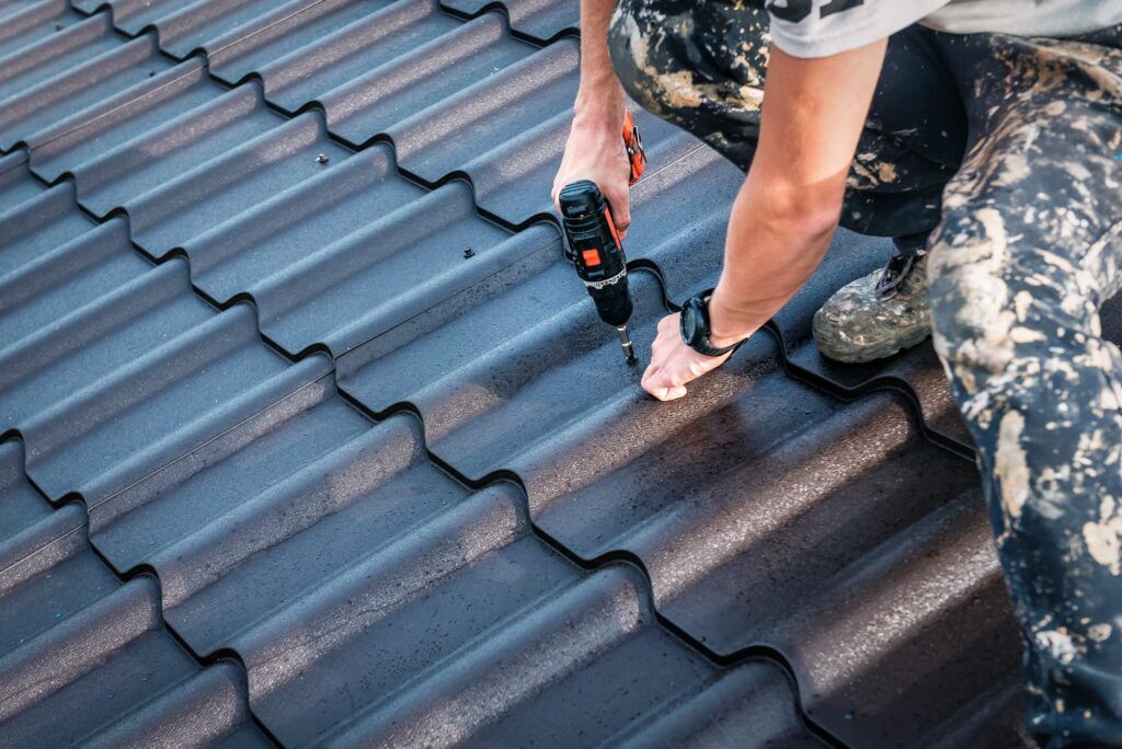 the worker screws the metal tile